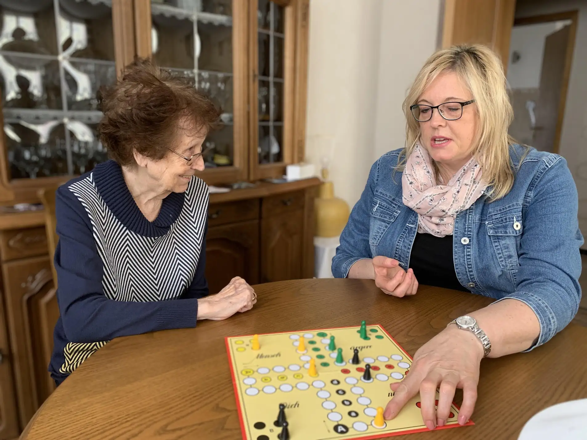 Alltagsbegleitung in Kaiserslautern: Alltagsbegleiterin spielt Mensch ärgere dich nicht mit Seniorin zu Hause